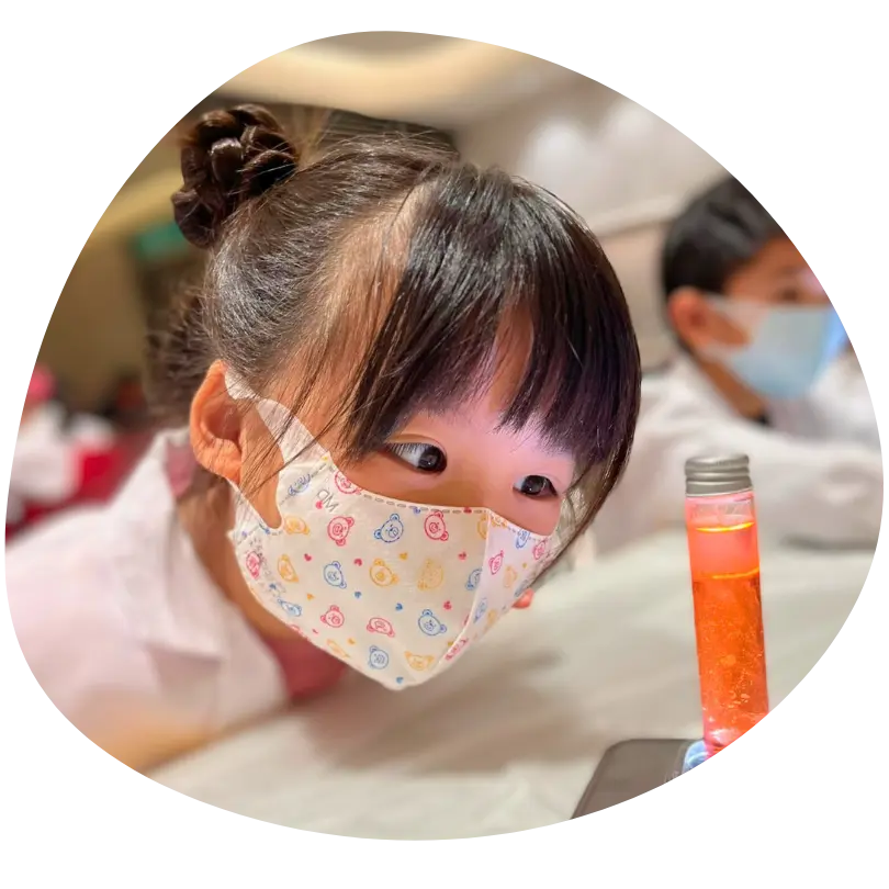 孩子好奇地觀察手上裝著彩色液體的試管